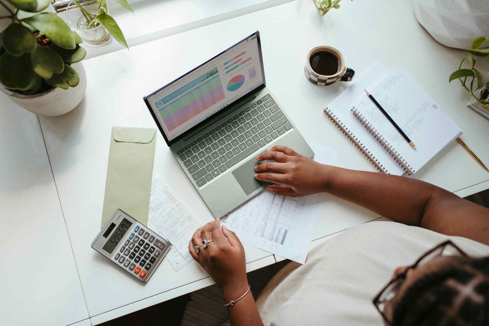 Práce na překladu na notebooku s dokumenty na stole